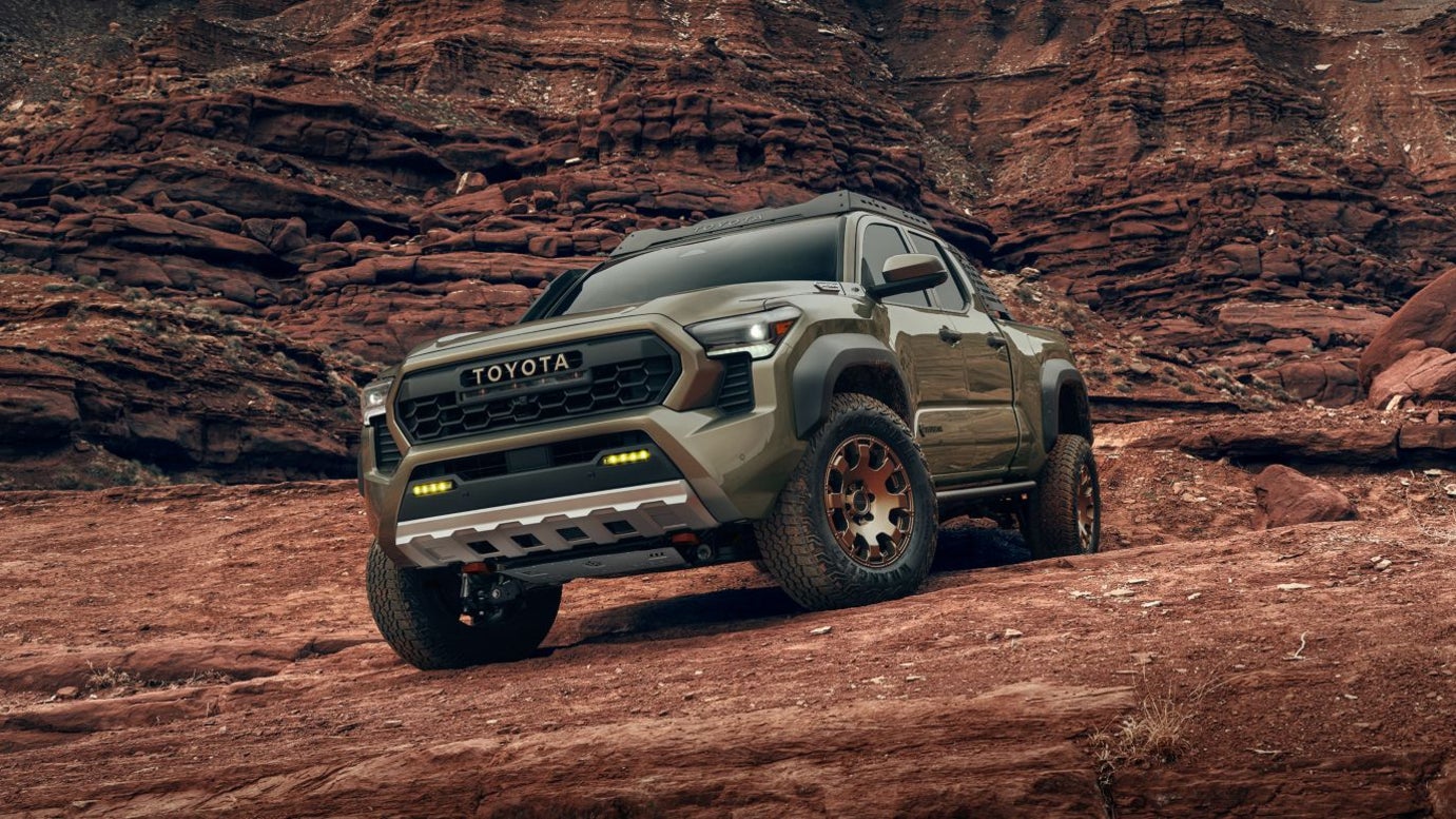 A green Toyota Tacoma parked on a rocky area.